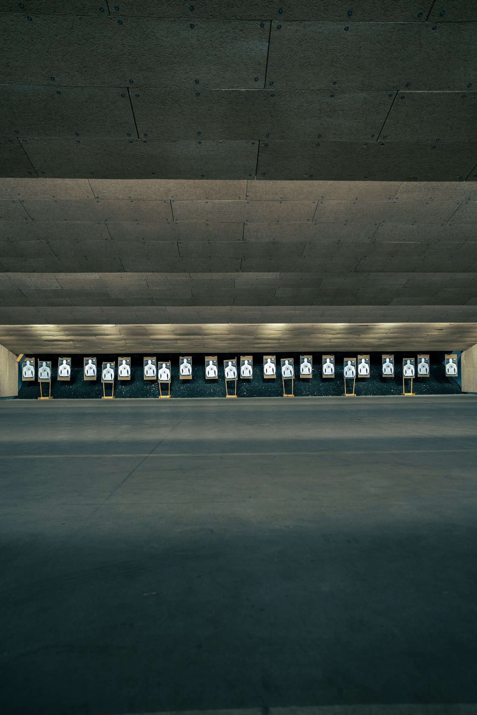 Indoor shooting range with silhouette targets set up for Achilles Heel Tactical carbine training