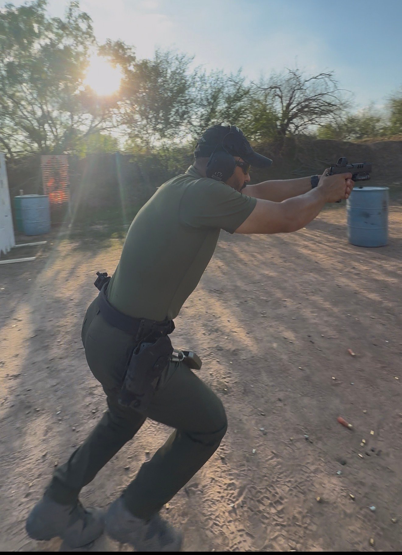 Jason Essazay of Mayer Security running a USPSA-style draw-and-engage drill at sunrise on a Texas range
